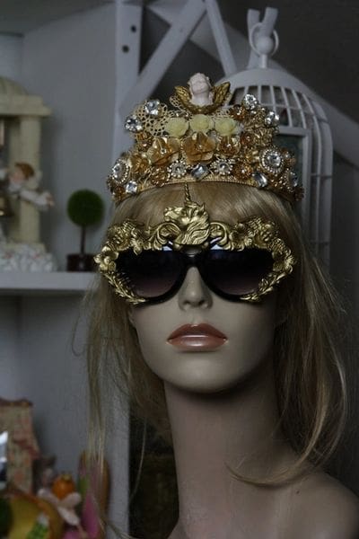 A mannequin wearing sunglasses and a crown.