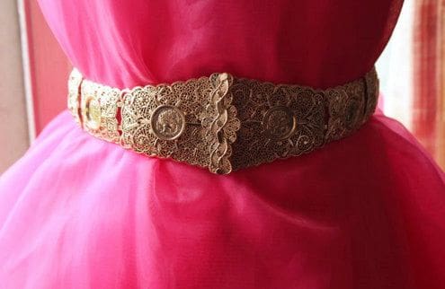 A close up of the waist of a woman wearing a red dress.