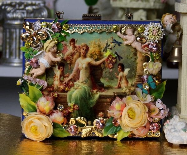 A picture of an old fashion purse with flowers and angels.