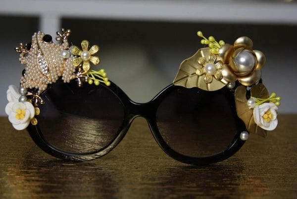 A pair of sunglasses with flowers and pearls on them.