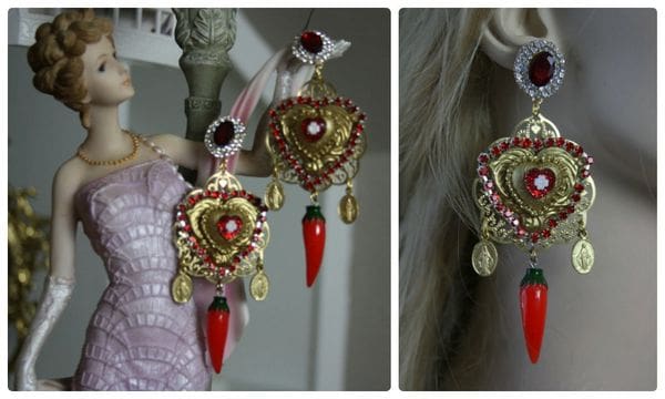 A pair of earrings with red and gold accents.