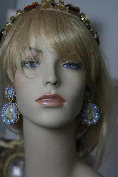 A mannequin wearing blue earrings and a crown.
