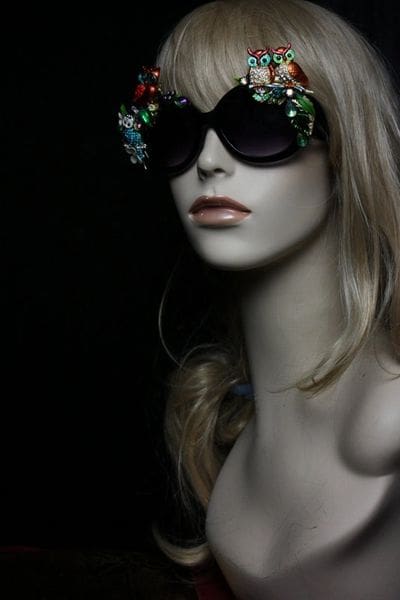 A mannequin wearing sunglasses and flowers in her hair.