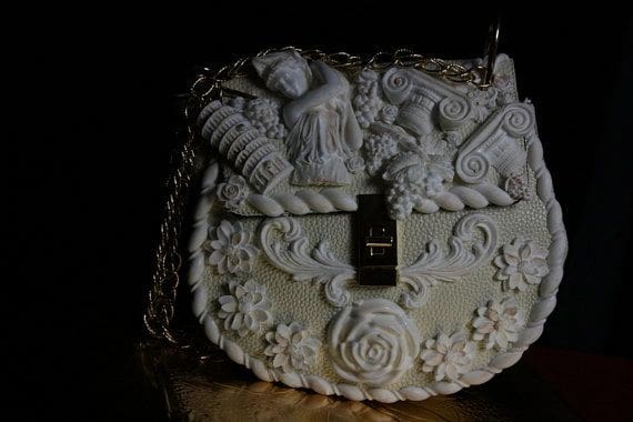A white purse with some carvings on it