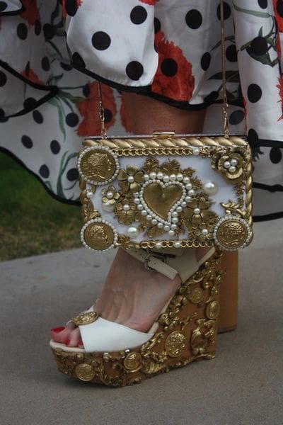 A pair of shoes and a purse on the ground.