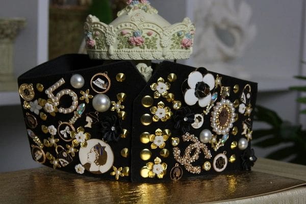 A black purse with gold and white embellishments.