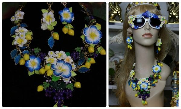 A woman wearing sunglasses and a necklace with flowers.