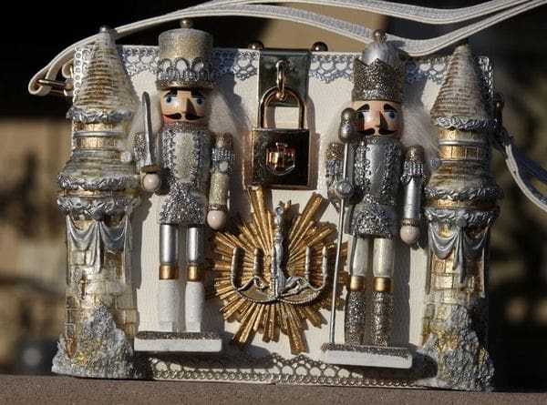 A silver and gold nutcracker scene with clock.