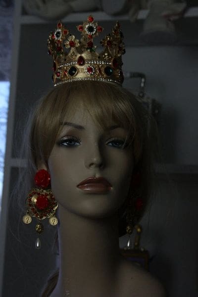 A mannequin wearing a crown and earrings.