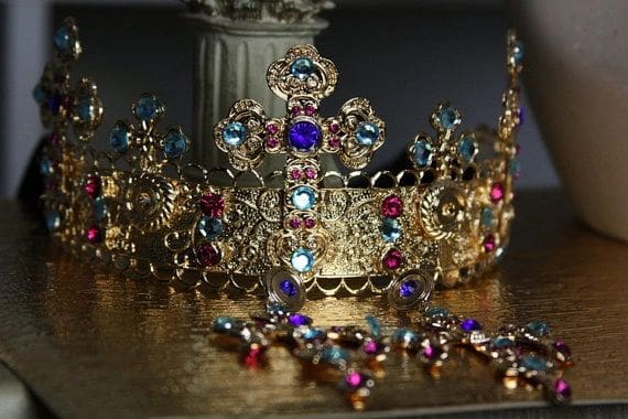 A crown and jewelry on top of a table.