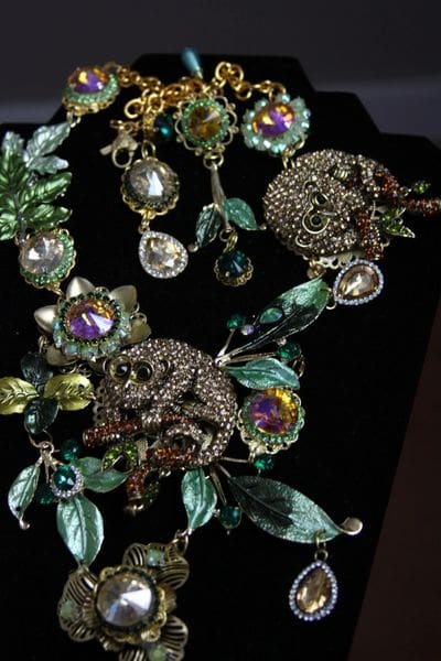 A necklace with green leaves and beads on it.