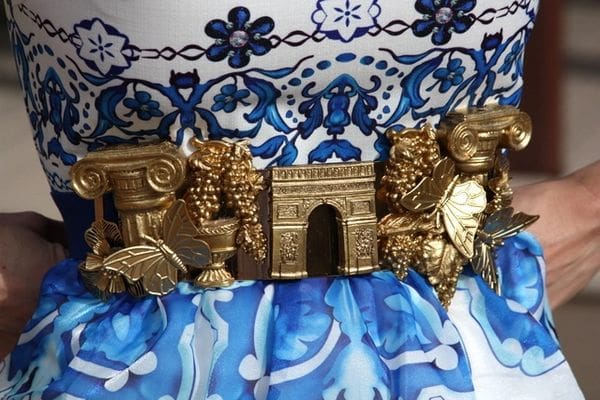 A close up of the golden statues on top of a blue and white wall