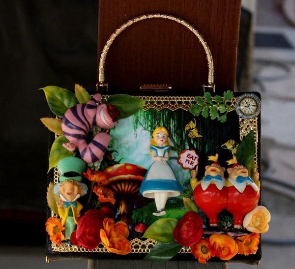 A purse with some images of alice in wonderland on it