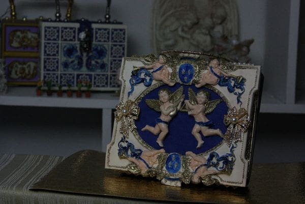 A picture frame with angels on it sitting on top of a table.