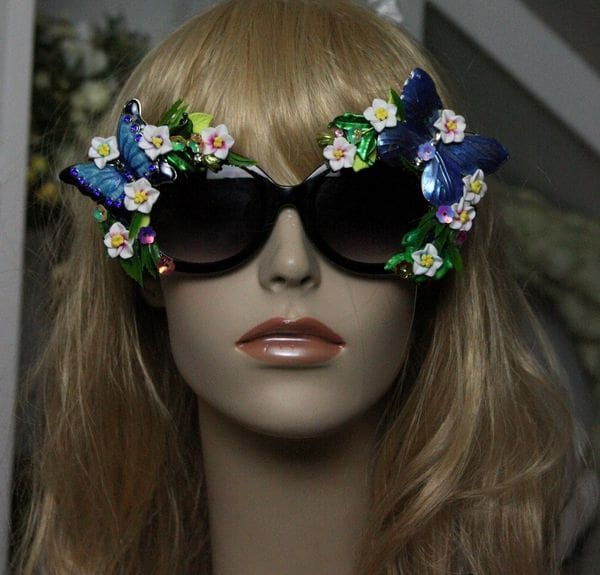 A mannequin wearing sunglasses with flowers and butterflies.