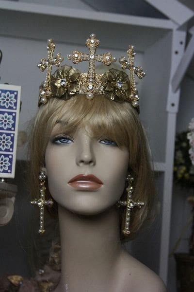 A mannequin wearing a crown and earrings.