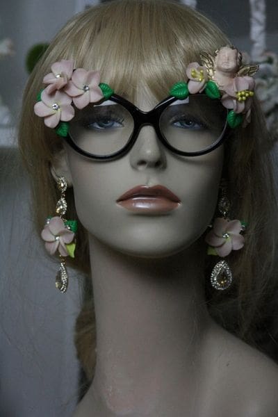 A mannequin wearing glasses and flowers in her hair.