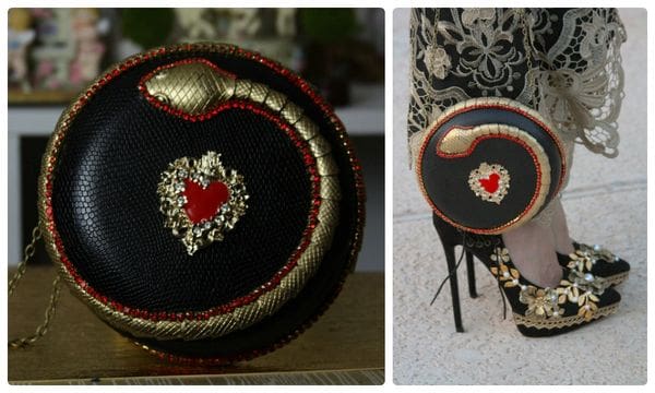 A black and red snake shaped bag next to a chair.