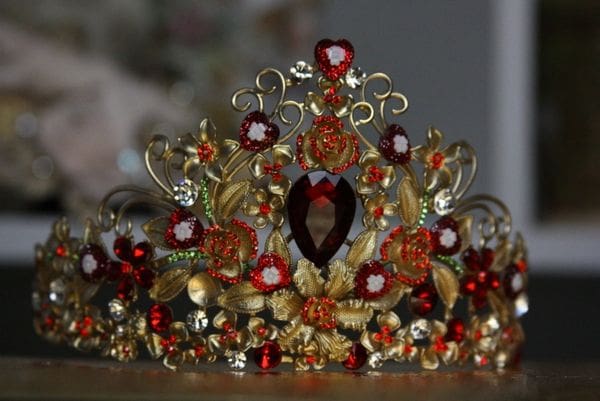 A tiara with red flowers and gold leaves.