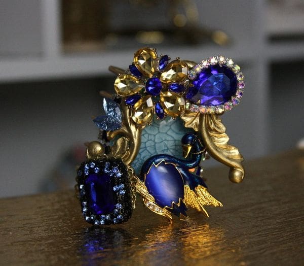 A blue and gold statue with some jewelry on it