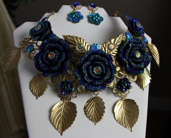 A necklace and earrings set with blue flowers.