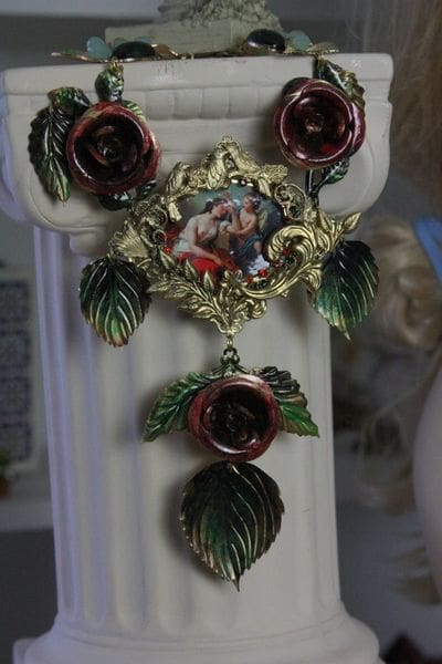 A cross with red roses and leaves hanging from it.