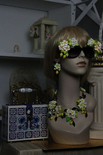 A mannequin wearing sunglasses and jewelry in a room.