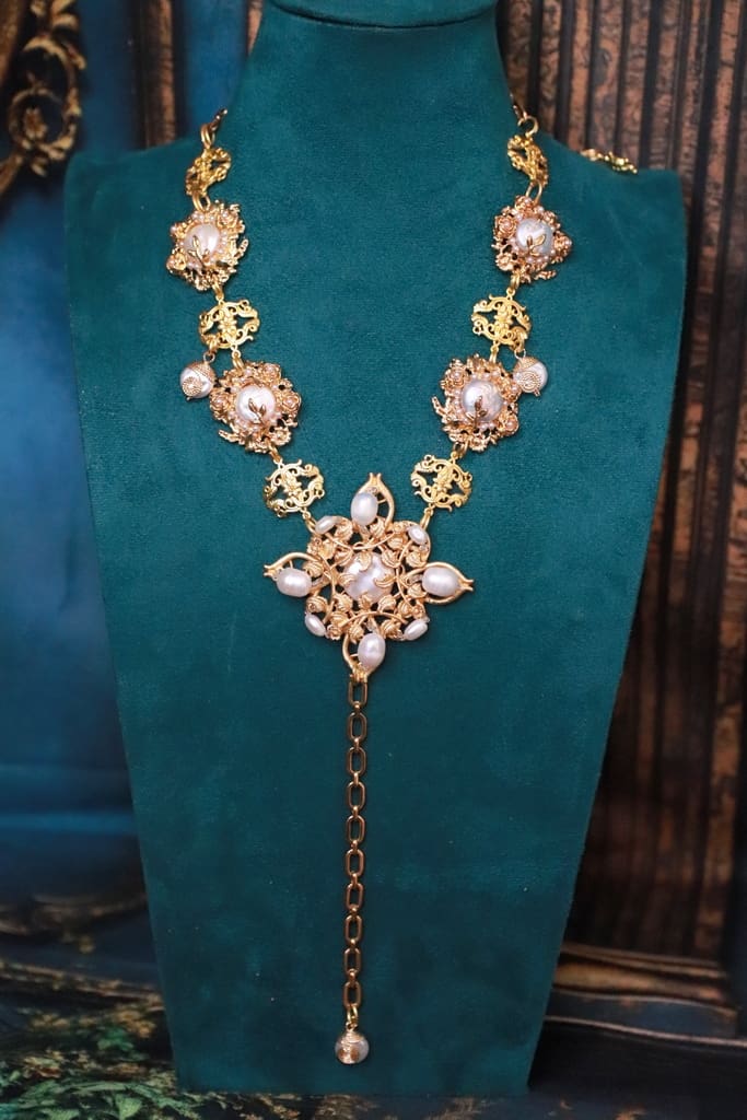 A necklace with pearls and gold on it
