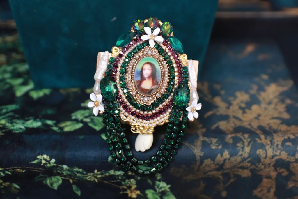A green and white necklace with a picture of jesus.