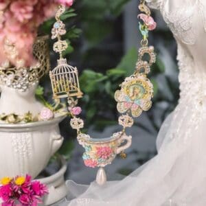 A necklace with a bird cage and flowers.