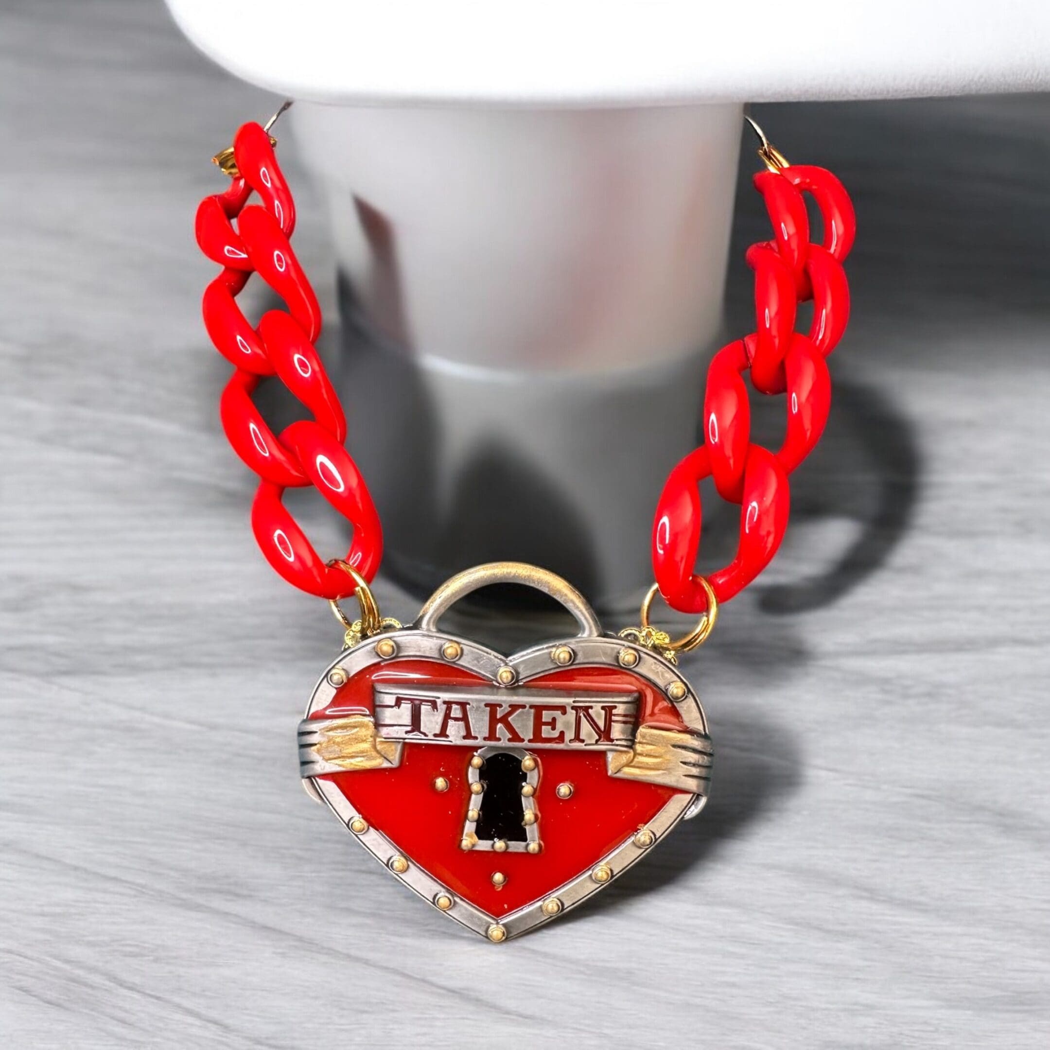 A red chain with a heart shaped lock on it.