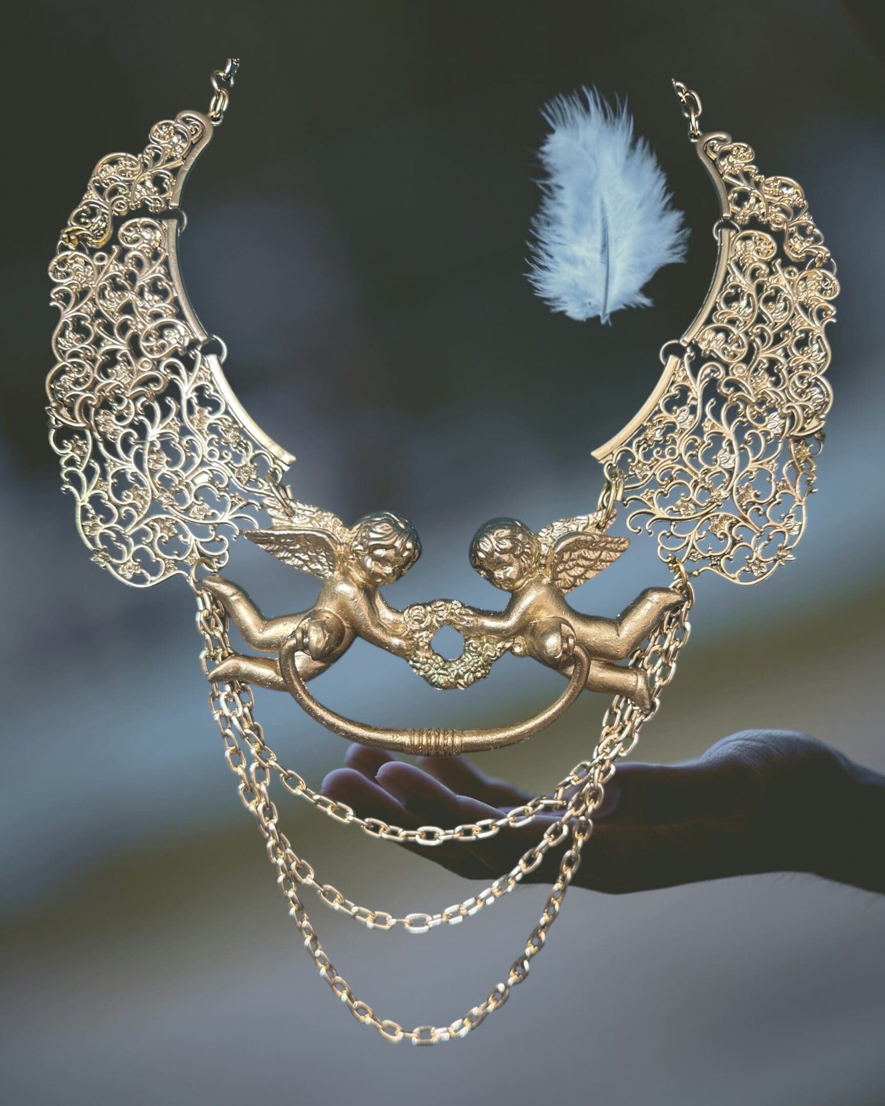 A necklace with two angels on it and feathers