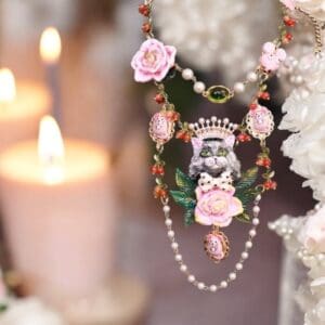 A necklace with pink flowers and pearls on it.