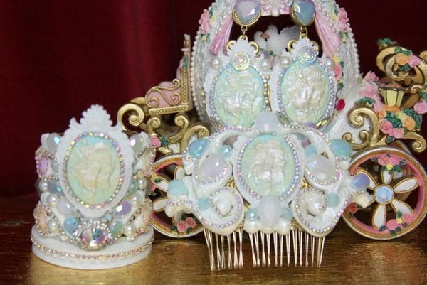 A large white and blue hair comb next to a small white and pink tiara.