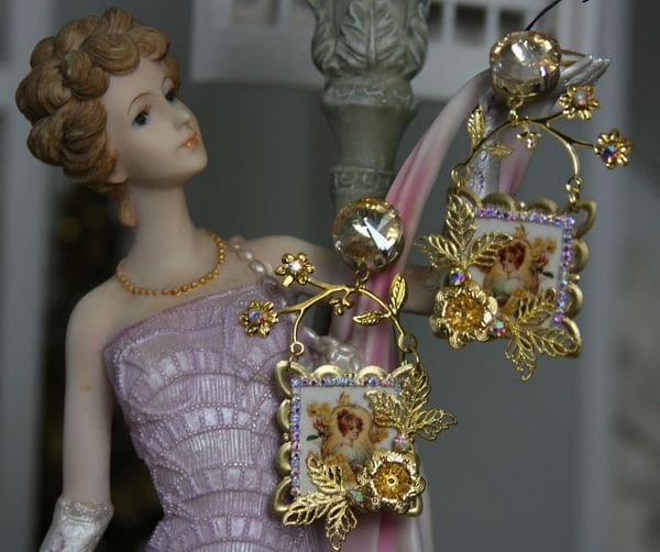 A statue of a woman in pink dress holding a pair of earrings.