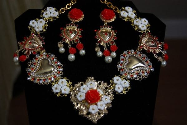 A necklace and earrings set with red roses.
