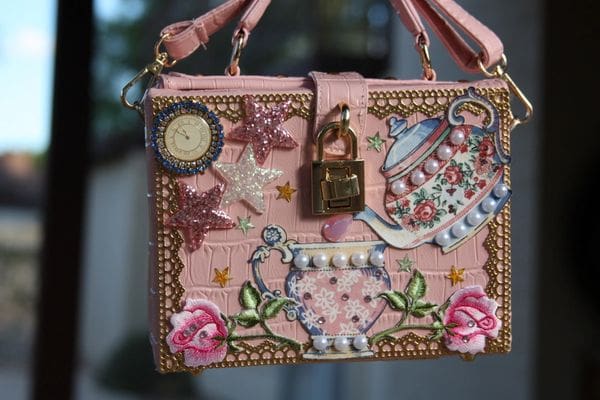 A pink purse with a lock and some flowers
