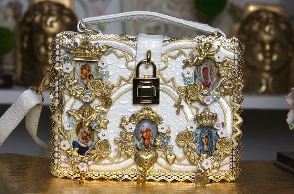 A white purse with gold trim and some pictures on it