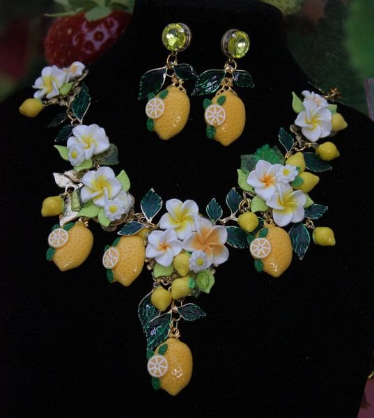 A necklace and earrings set with lemons, flowers and leaves.